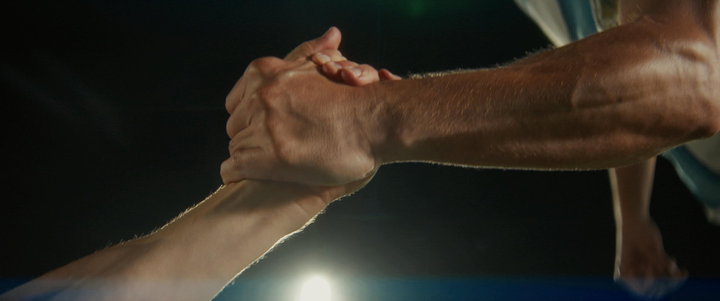 Still from the Argentina football commercial: a handshake in dramatic light
