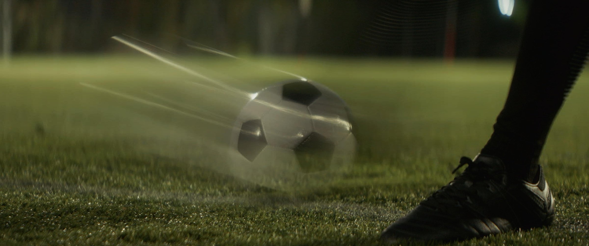 Still from the Argentina football commercial: a boot striking a football on night turf