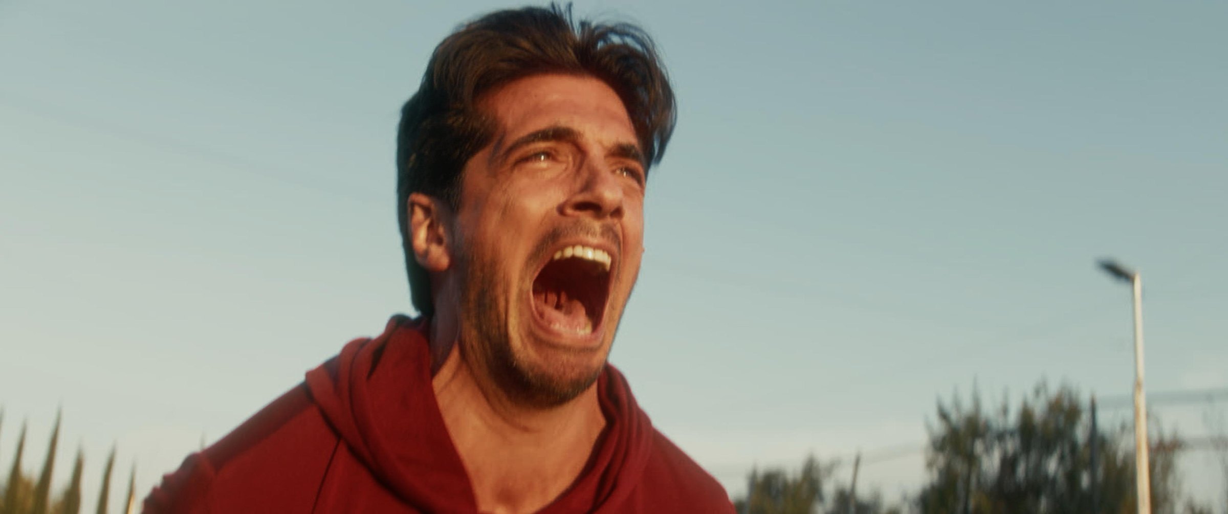Still from the Argentina football commercial: a fan in a red hoodie shouting in celebration