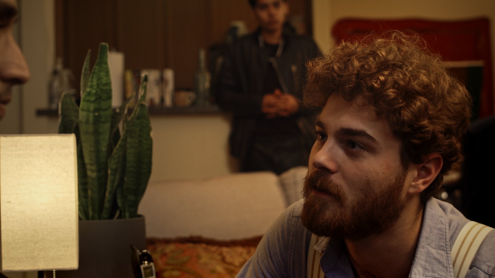 Still from God's Second Best Man: an over-the-shoulder view of a conversation