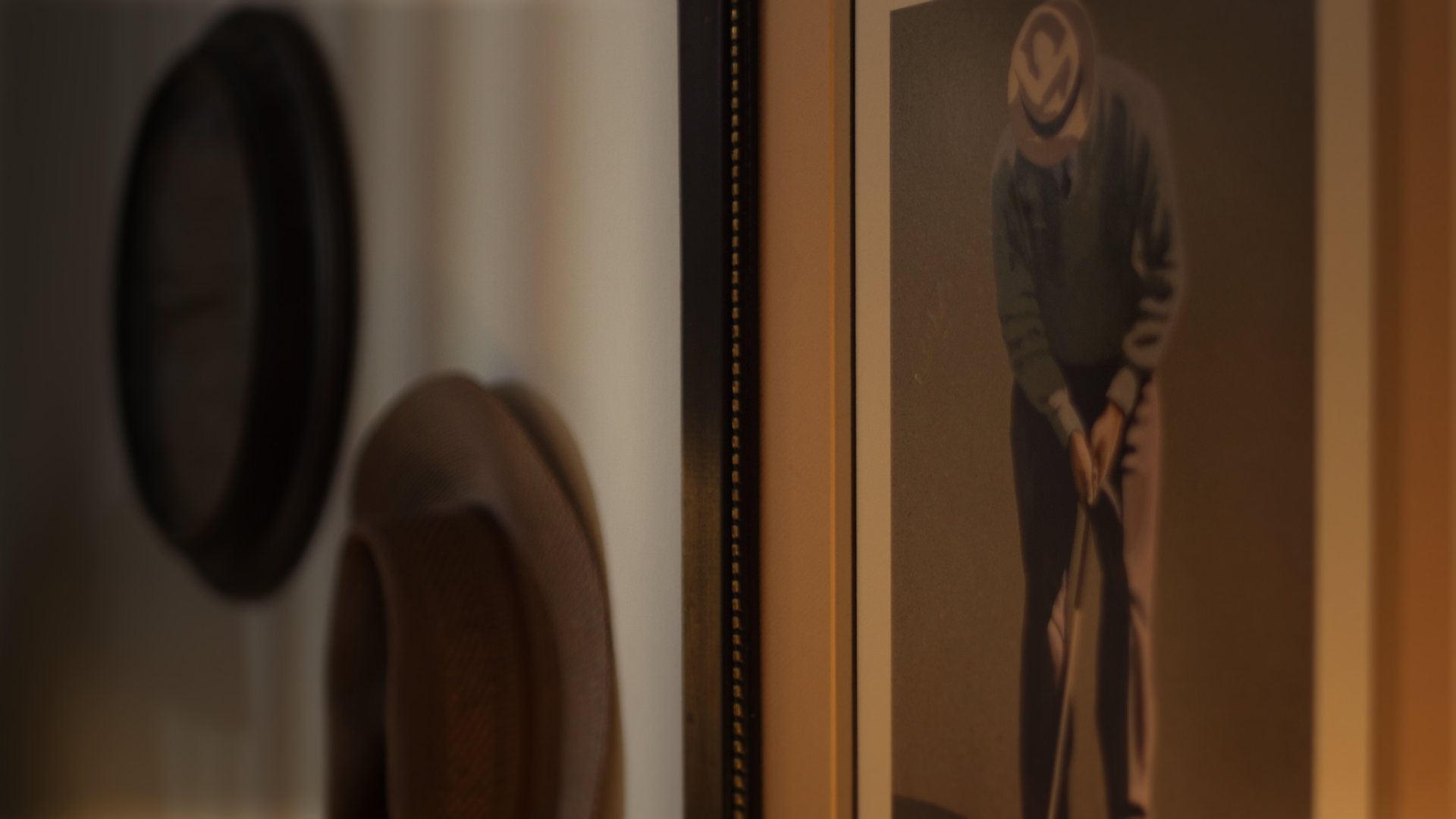 Still from God's Second Best Man: framed pictures on a wall in shallow focus