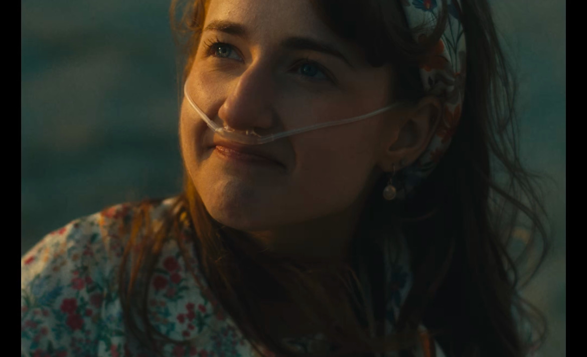 Still from What's Life: a girl with a nasal cannula smiling softly