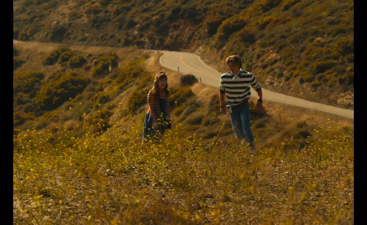 Still from What's Life: two people walking a hillside road