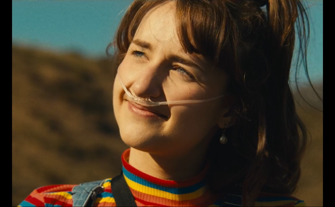 Still from What's Life: a girl smiling on a golden hillside